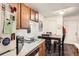 Traditional kitchen with wood cabinets, dining area, white appliances, and white walls at 1358 S Irving St # 53, Denver, CO 80219