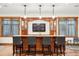 Basement bar with seating and custom cabinetry at 9250 Steeplechase Dr, Franktown, CO 80116