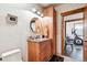 Stylish bathroom featuring custom wood cabinetry, granite countertop, round mirror, and modern lighting at 9250 Steeplechase Dr, Franktown, CO 80116