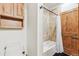 Bathroom featuring a tiled tub with shower and a solid wood door at 9250 Steeplechase Dr, Franktown, CO 80116