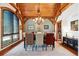 Elegant dining room with wood beams, stylish lighting, and large windows providing natural light at 9250 Steeplechase Dr, Franktown, CO 80116