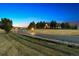Elegant home exterior at dusk, showcasing a long driveway at 9250 Steeplechase Dr, Franktown, CO 80116