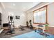 Well-lit home gym with various workout equipment and padded flooring for comfortable exercise at 9250 Steeplechase Dr, Franktown, CO 80116