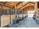 Inside view of horse stalls with metal bars and wood walls at 9250 Steeplechase Dr, Franktown, CO 80116