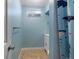 Small basement bathroom with shower, tile floor, and light blue walls at 11310 Irma Dr, Northglenn, CO 80233