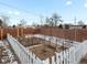 Backyard garden with raised beds, small tree, and white fence at 11310 Irma Dr, Northglenn, CO 80233