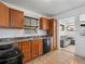 Kitchen with wood cabinets, black appliances, and tile flooring at 11310 Irma Dr, Northglenn, CO 80233