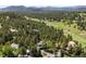 Scenic aerial view of the property showcases mature trees, landscape, and mountain views in the background at 2122 Cramner Ct, Evergreen, CO 80439