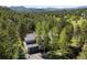 Aerial view of the house shows a shingled roof, mature trees, and a driveway with basketball hoop at 2122 Cramner Ct, Evergreen, CO 80439