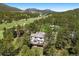 Aerial view of a gorgeous home nestled in a tranquil forest with lush trees and stunning mountain backdrop at 2122 Cramner Ct, Evergreen, CO 80439