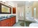 Luxurious bathroom featuring a double vanity, large soaking tub, and glass shower at 2122 Cramner Ct, Evergreen, CO 80439