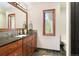 Bathroom featuring granite countertop, wood cabinetry, a framed mirror, natural light from window, and toilet area at 2122 Cramner Ct, Evergreen, CO 80439