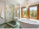 Stunning bathroom featuring a glass shower, large soaking tub, and natural light at 2122 Cramner Ct, Evergreen, CO 80439