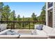 Outdoor seating with plush couches on deck overlooking mountain views and mature trees at 2122 Cramner Ct, Evergreen, CO 80439