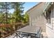 Outdoor deck with wood railings features a dining table with seating and views of a lush evergreen forest at 2122 Cramner Ct, Evergreen, CO 80439