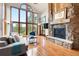 Living room boasts a stone fireplace, hardwood floors, and large windows with a scenic view at 2122 Cramner Ct, Evergreen, CO 80439