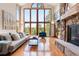 Bright living room featuring a stone fireplace, hardwood floors, and large windows with a view at 2122 Cramner Ct, Evergreen, CO 80439