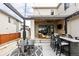 Covered back patio with stone wall, outdoor seating, ceiling fan, TV, and built-in bar for entertaining at 5985 Galena St, Denver, CO 80238