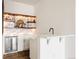 Elegant bar area featuring open shelves, wine fridge, and stylish marble backsplash at 5985 Galena St, Denver, CO 80238