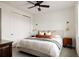 Bright bedroom featuring a king-sized bed, cozy textiles, ceiling fan and stylish sconces at 5985 Galena St, Denver, CO 80238