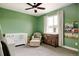 Adorable Bedroom with a white crib, comfortable chair, and whimsical decor and a ceiling fan above at 5985 Galena St, Denver, CO 80238