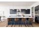 Modern kitchen featuring a large island with bar seating, stylish pendant lighting, and stainless steel appliances at 5985 Galena St, Denver, CO 80238