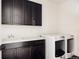 Convenient laundry room with ample storage, modern washer and dryer, and bright countertops at 5985 Galena St, Denver, CO 80238