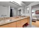 Bathroom with dual sinks, vanity, decorative tile and large mirrors and ample lighting at 1401 Wewatta St # 202, Denver, CO 80202
