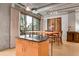 Open floor plan showing kitchen island with dining room with balcony access and concrete ceiling at 1401 Wewatta St # 202, Denver, CO 80202