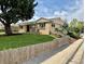 Quaint home with a large tree and a charming wooden fence at 1801 S Grove St, Denver, CO 80219