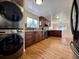 Kitchen with dark cabinetry, stainless steel appliances, and stacked laundry at 1801 S Grove St, Denver, CO 80219