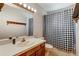 Bathroom featuring sink, toilet, and checkered shower curtain at 9040 Raleigh St, Westminster, CO 80031
