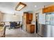Open-concept kitchen and dining area with stainless steel refrigerator and wood cabinets at 9040 Raleigh St, Westminster, CO 80031