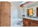 Bathroom featuring a double sink vanity, tiled shower, and neutral color scheme at 15566 E Louisiana Ave, Aurora, CO 80017