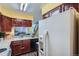 Kitchen with wood cabinets, white countertops, and a view of a staircase leading to the upper level at 15566 E Louisiana Ave, Aurora, CO 80017