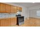 Eat-in Kitchen features stainless steel gas range, wooden cabinets, and hardwood floors at 127 S Perry St, Denver, CO 80219