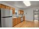 Bright kitchen with stainless steel appliances, natural wood cabinets, and hardwood floors at 127 S Perry St, Denver, CO 80219