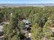 Aerial view of a home nestled among a dense forest of mature trees and distant mountain views at 484 Hyland Dr, Castle Rock, CO 80108