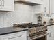 Close-up of a stainless steel range and white tile backsplash in a modern kitchen at 484 Hyland Dr, Castle Rock, CO 80108