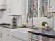 Close-up of a white farmhouse sink, stainless steel faucet, and white cabinetry in a modern kitchen at 484 Hyland Dr, Castle Rock, CO 80108