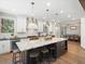 Bright kitchen with a large island, white cabinets, stainless steel appliances, and hardwood floors at 484 Hyland Dr, Castle Rock, CO 80108