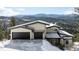 Modern home exterior with two-car garage and mountain backdrop at 26467 Bell Park Dr, Evergreen, CO 80439