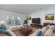 Bright living room with stylish furniture, a large TV, and a sliding glass door to a balcony at 755 S Alton Way # 9D, Denver, CO 80247