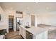Open concept kitchen with stainless steel appliances, quartz counters, walk-in pantry, and an island with a sink at 11052 Snowdon St, Parker, CO 80134