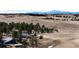 Expansive property featuring rolling hills, mature trees, and a charming farmhouse against a backdrop of snow-capped mountains at 1991 County Road 132, Elizabeth, CO 80107