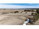 Wide aerial view of a large property with rolling land, trees, and distant homes in the background at 1991 County Road 132, Elizabeth, CO 80107