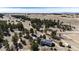 Aerial view showcasing the rural property with a long drive, home, outbuildings, and scattered trees at 1991 County Road 132, Elizabeth, CO 80107