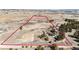 This aerial view showcases the expansive acreage featuring a home, outbuildings, and riding arena with a striking red perimeter at 1991 County Road 132, Elizabeth, CO 80107