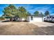 Exterior view of a detached garage with white door, driveway and additional parking for a camper at 1991 County Road 132, Elizabeth, CO 80107