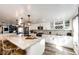 Bright kitchen features modern cabinets, stainless steel appliances, marble countertops, wine rack, and unique pendant lighting at 1991 County Road 132, Elizabeth, CO 80107